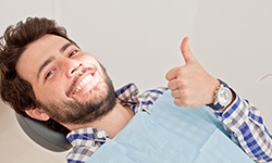 man smiling in the dentist chair after learning the cost of cosmetic options