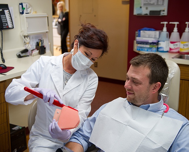 Dentist helping patient understand how to brush teeth correctly