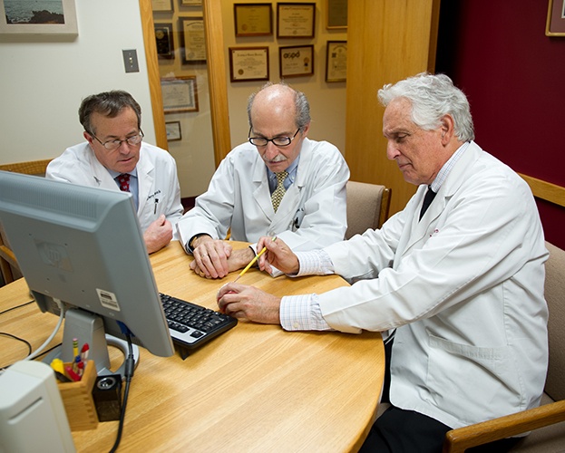 Three doctors discussing patient treatment plan together