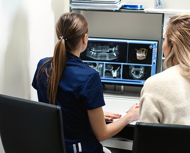 Dentist and dental team member looking at all digital x-rays