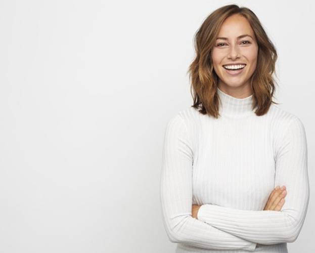 woman smiling with a white background working with an implant dentist in Williamsville