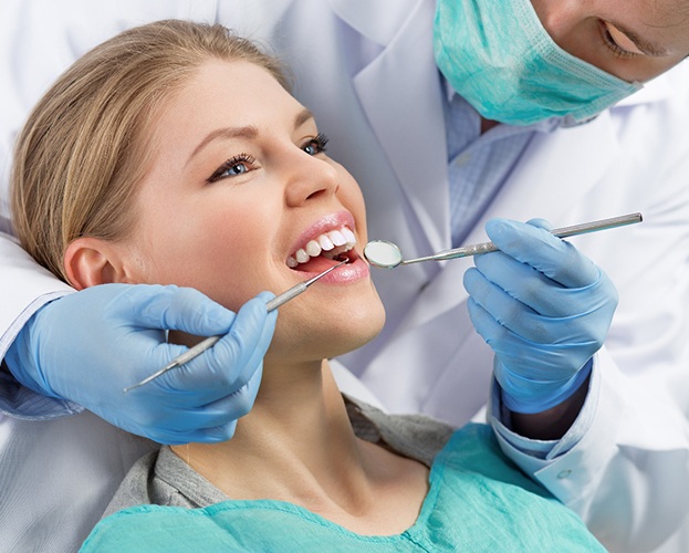 dentist looking in a smiling patient’s mouth