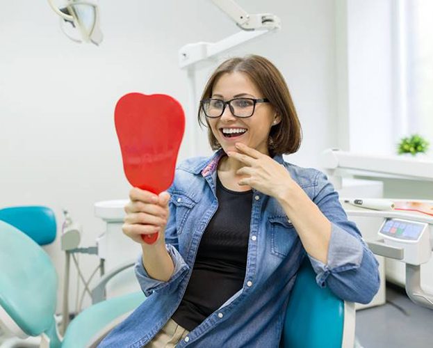 young woman admiring her new dental implants in Williamsville