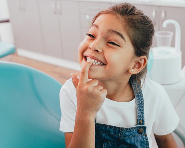 Little girl pointing to tooth colored filling