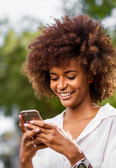 Woman smiling at her cell phone