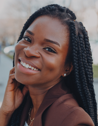 Young woman grinning outdoors