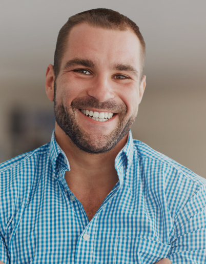 Man in blue plaid shirt grinning