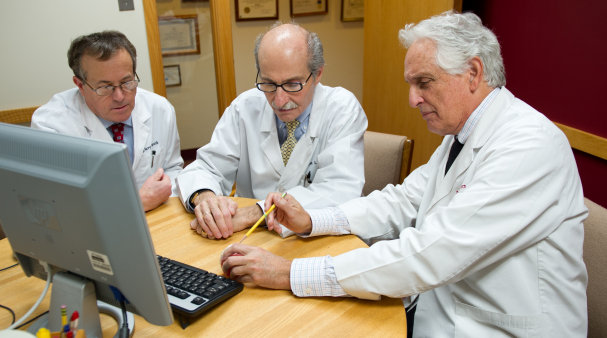 Three dentists in Williamsville sitting at desk with computer