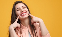 woman smiling after choosing Invisalign over Smile Direct Club
