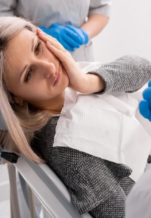 woman visiting dentist with jaw pain 