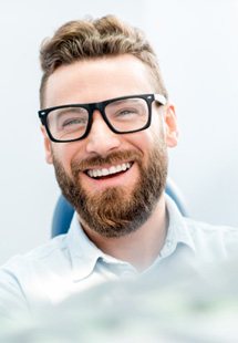 patient smiling while sitting in dental chair