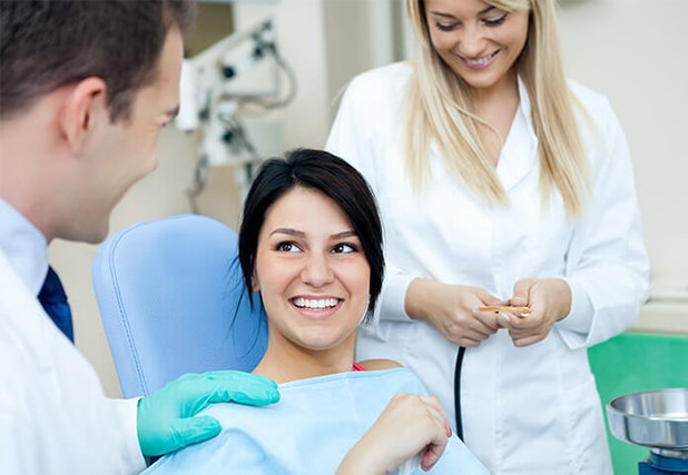 Woman in dental chair smiling at dentist