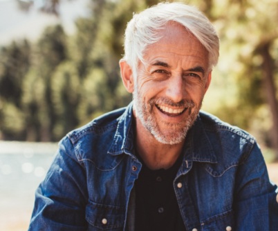 Man smiling after replacing missing teeth