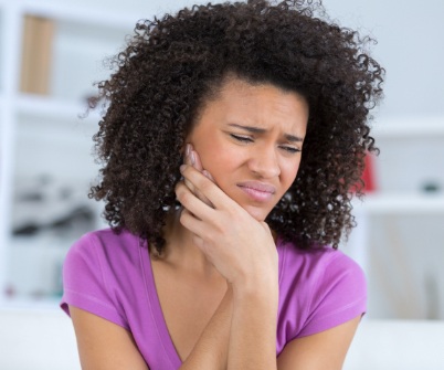 Woman in need of emergency dentistry holding jaw in pain