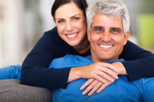  attractive older couple smiling on a sofa