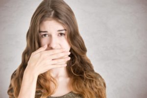 young woman covering mouth 