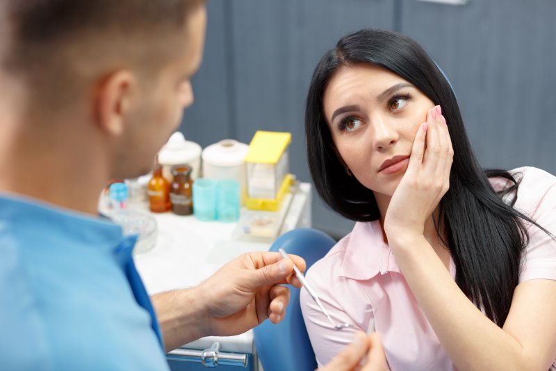 A woman talking to her dentist about a root canal retreatment