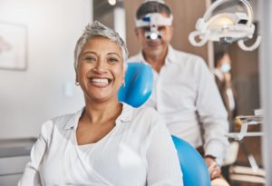 woman smiling with the dentist in the background