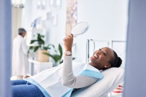happy dental patient looking in the mirror after treatment