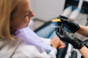 patient talking about Invisalign with her gloved dentist