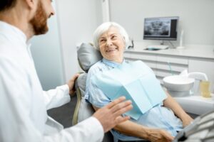 smiling older lady talking to her dentist about dental implants