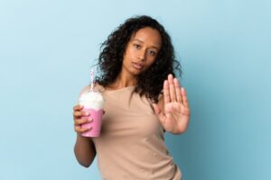 woman holding a shake with her hand out to say stop