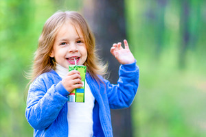 Little girl drinking out of a juice box